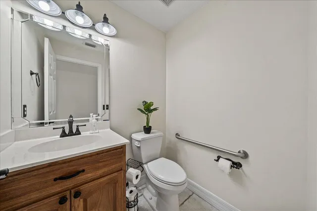 a bathroom with a sink vanity mirror and toilet