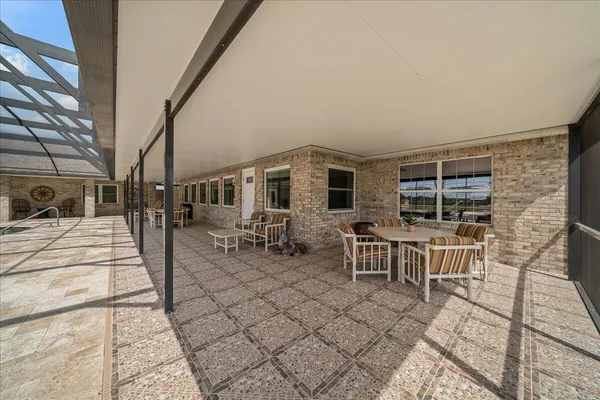 a view of a patio with dining table and chairs with wooden floor