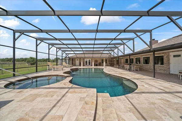 a view of a house with backyard water fountain and sitting area