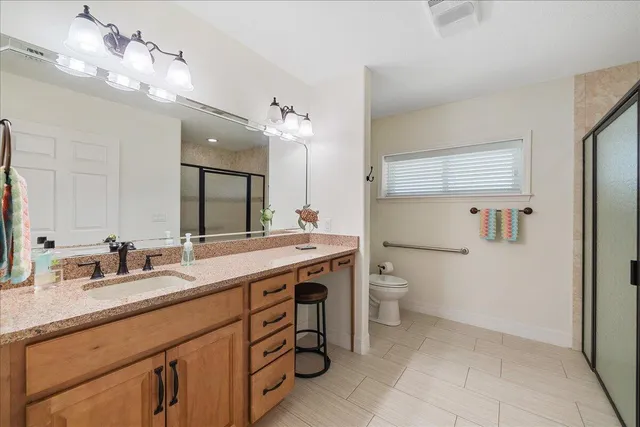 a spacious bathroom with a granite countertop sink a toilet and a mirror