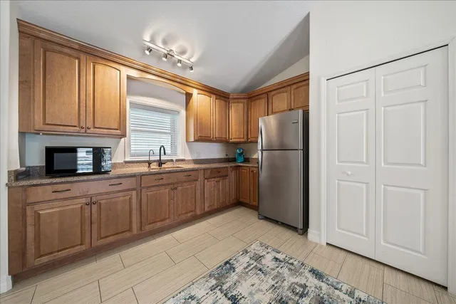 a kitchen with a refrigerator a sink and cabinets