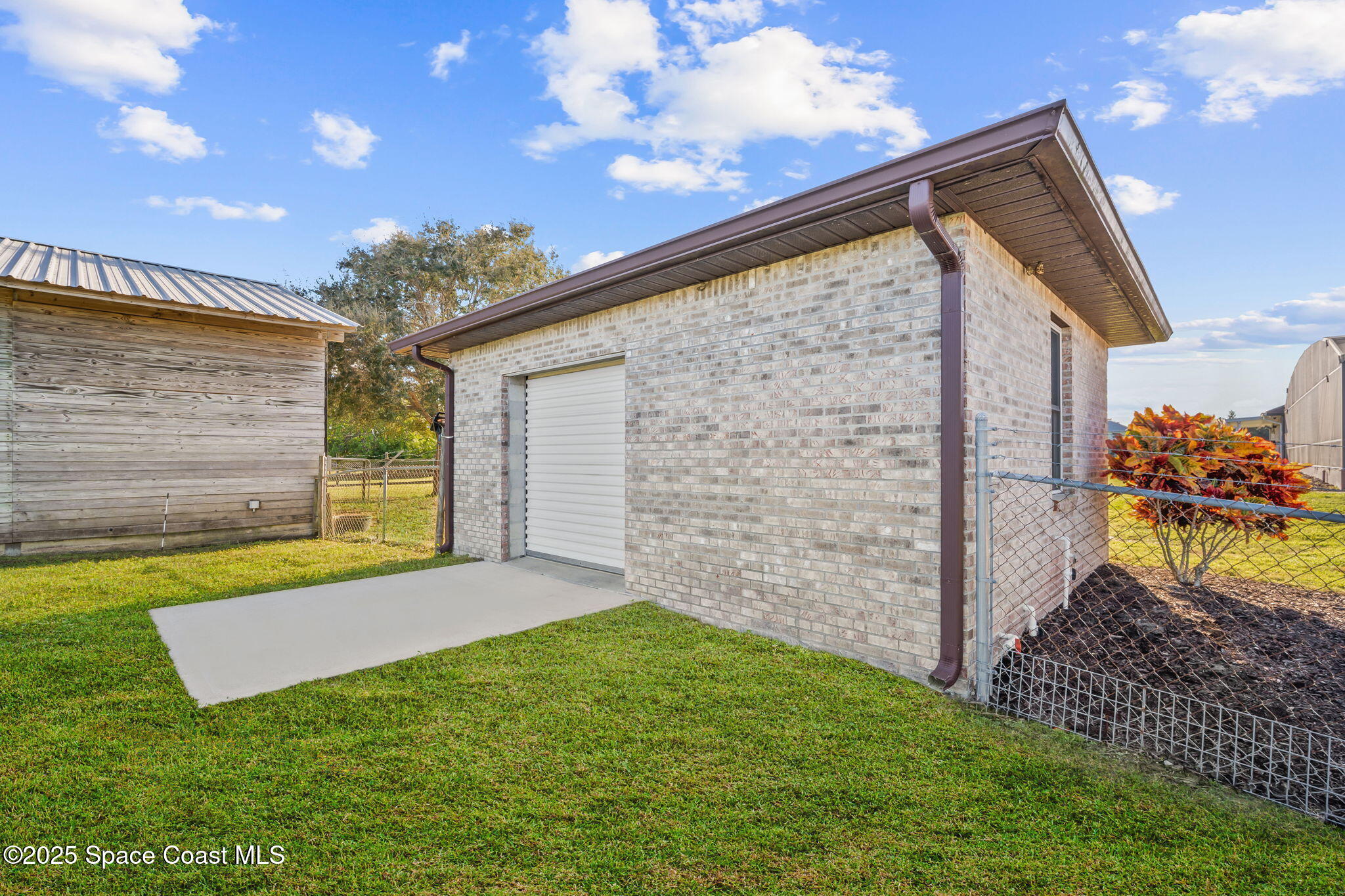 3125 Davis Road Mims, FL 32754 - Photo 40 of 46 a view of a backyard with brick wall and a garage