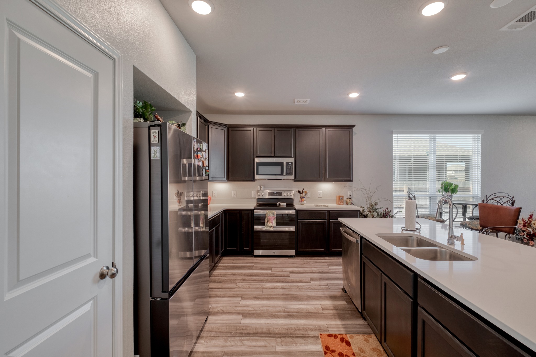 3500 Beutel Road Lorena, TX 76655 - Photo 12 of 27 Kitchen with stainless steel appliances, dark wood finish cabinets, recessed lighting, light wood-style flooring, and light stone counters