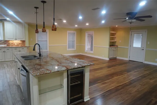 a kitchen with kitchen island a counter top a stove and a wooden floor