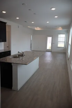 a view of kitchen with granite countertop sink and stove