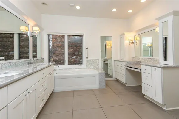 a spacious bathroom with a double vanity sink a large mirror and a shower