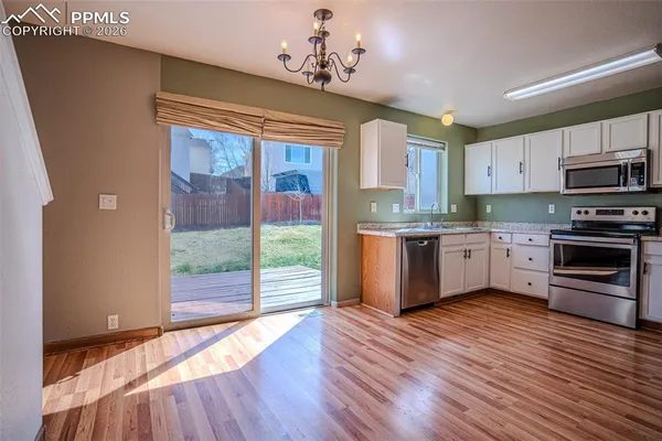 a kitchen with stainless steel appliances a sink cabinets and wooden floor
