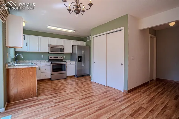 a kitchen with stainless steel appliances wooden floors and wooden cabinets