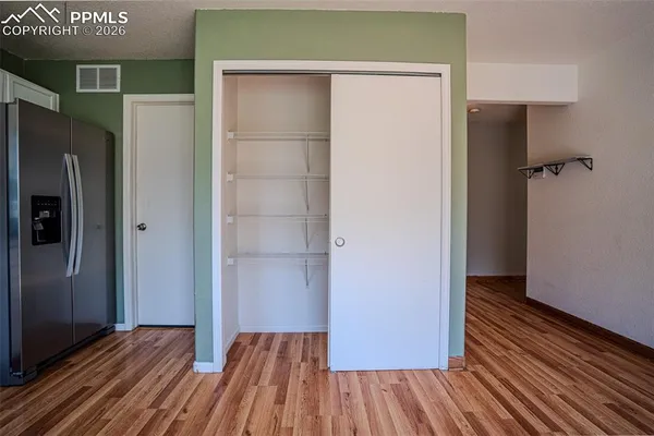 a view of a room with wooden floor and a hallway