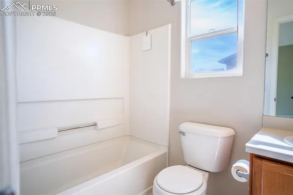 a white toilet sitting next to a bath tub
