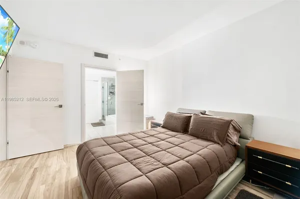 a bedroom with a bed and a mirror