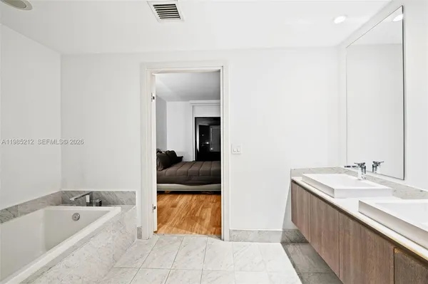 a en suite bathroom with a tub sink and mirror