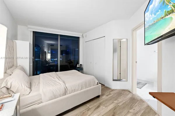 a bedroom with a large bed and a walk in closet