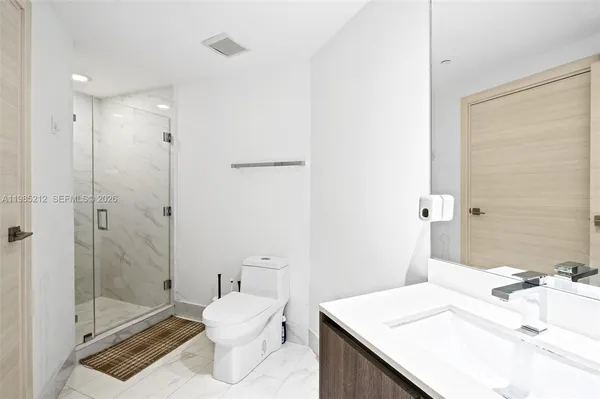 a bathroom with a sink a toilet and shower