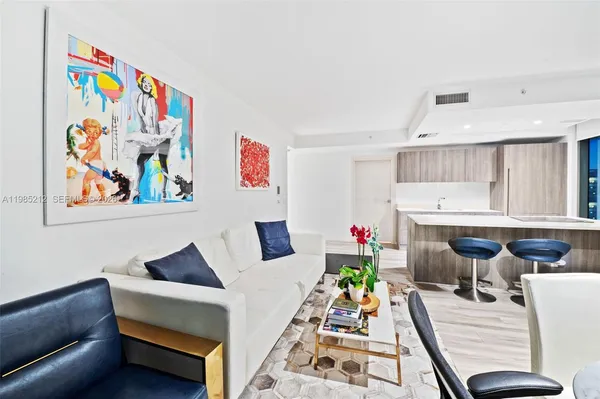 a living room with furniture and painting on the wall