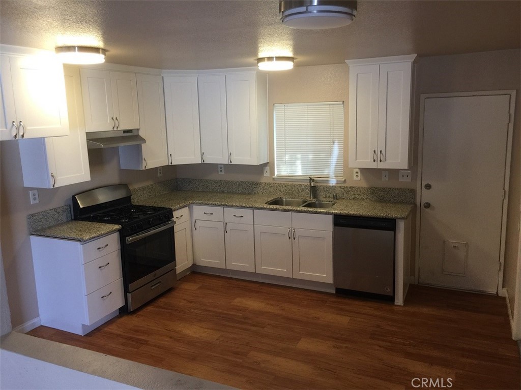20955 Little Beaver Road, Unit 2 Apple Valley, CA 92308 - Photo 2 of 8 a kitchen with granite countertop a sink cabinets and stainless steel appliances