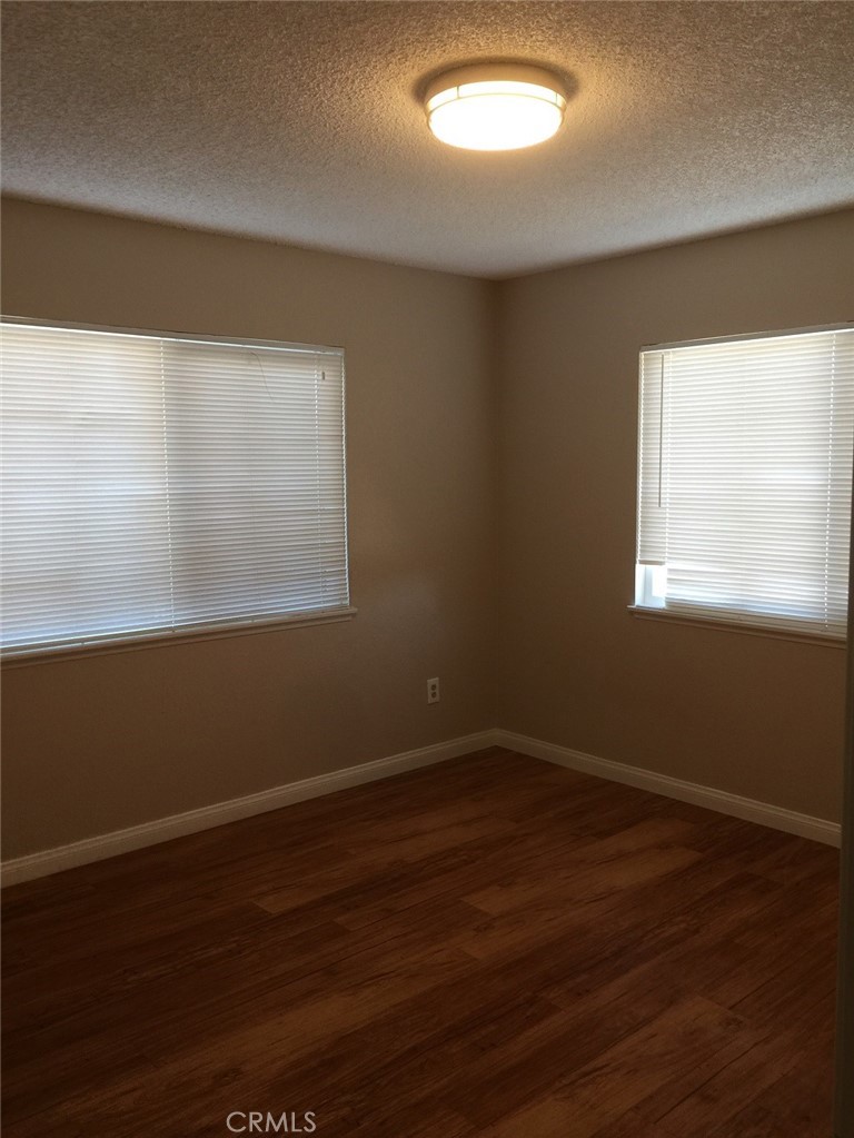 20955 Little Beaver Road, Unit 2 Apple Valley, CA 92308 - Photo 5 of 8 a view of a room with wooden floor and windows