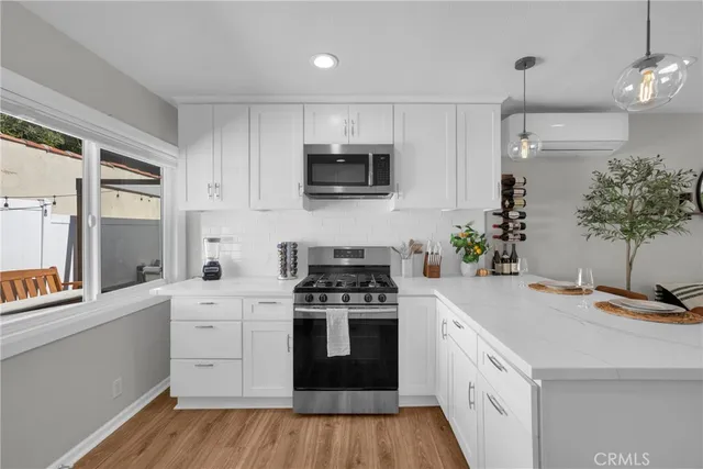 a kitchen with white cabinets and stainless steel appliances
