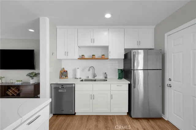 a kitchen with a refrigerator sink and white cabinets