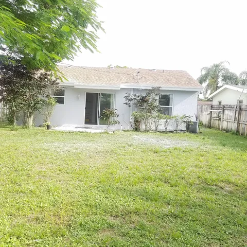 a large house with a big yard and large trees