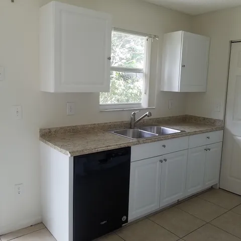 a kitchen with a sink cabinets and window