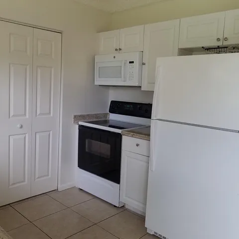 a kitchen with white cabinets and white stainless steel appliances