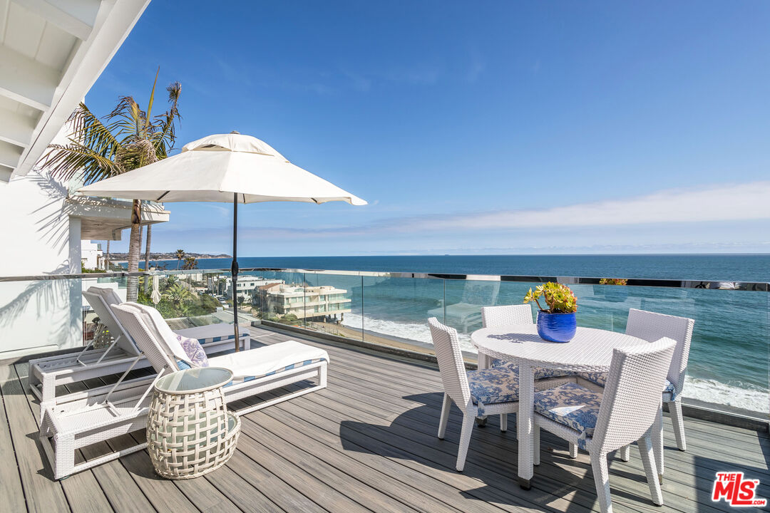 a view of deck with table and chairs under an umbrella with wooden floor