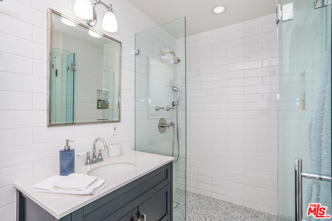 31658 Broad Beach Road Malibu, CA 90265 - Photo 32 of 50 a bathroom with a sink vanity granite shower and a mirror