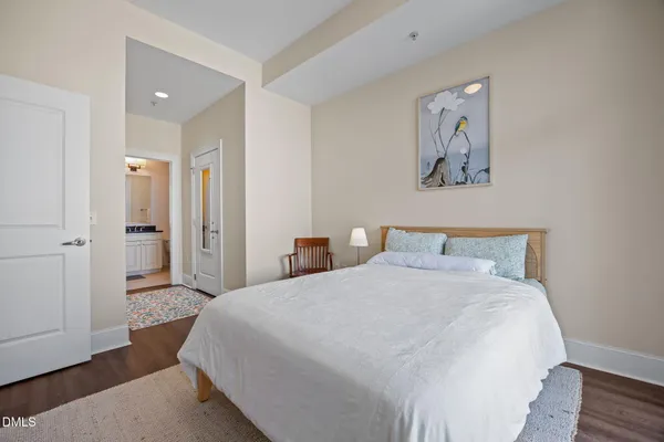 a spacious bedroom with a bed and a painting on the wall