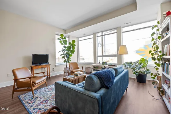 a living room with furniture potted plant and a large window