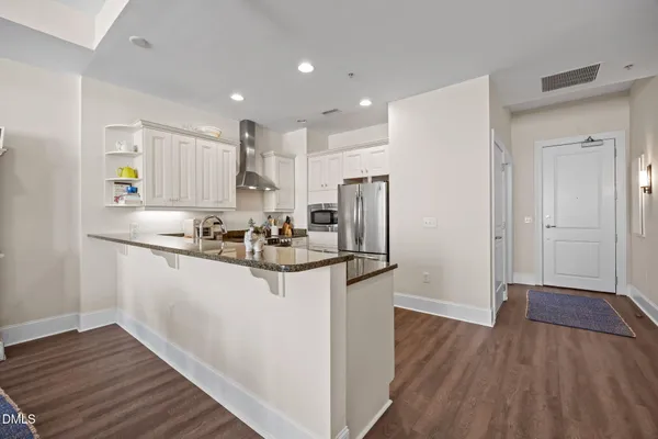 a kitchen with stainless steel appliances granite countertop a refrigerator and a stove top oven