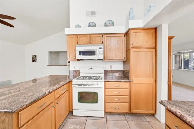 a kitchen with granite countertop cabinets stainless steel appliances and a counter space