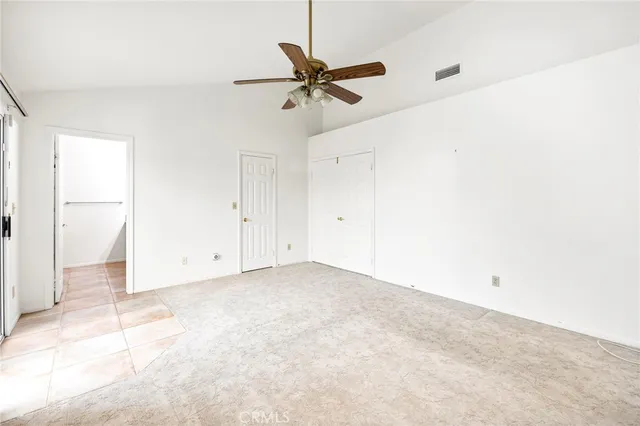 a view of a room with a ceiling fan and window