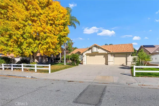 a view of a house with a yard and large trees