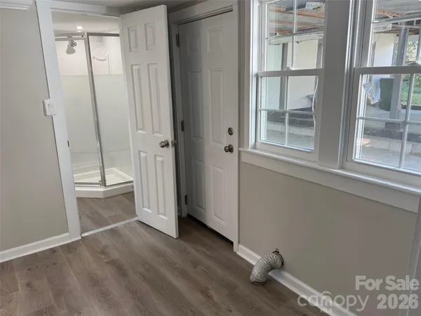 an empty room with wooden floor and windows