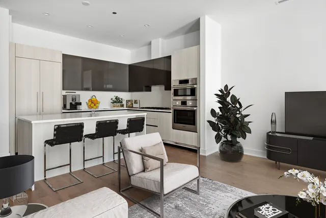 a kitchen with stainless steel appliances a stove a sink a microwave a dining table and chairs