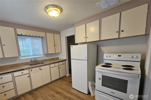 a kitchen with a white cabinets and white appliances