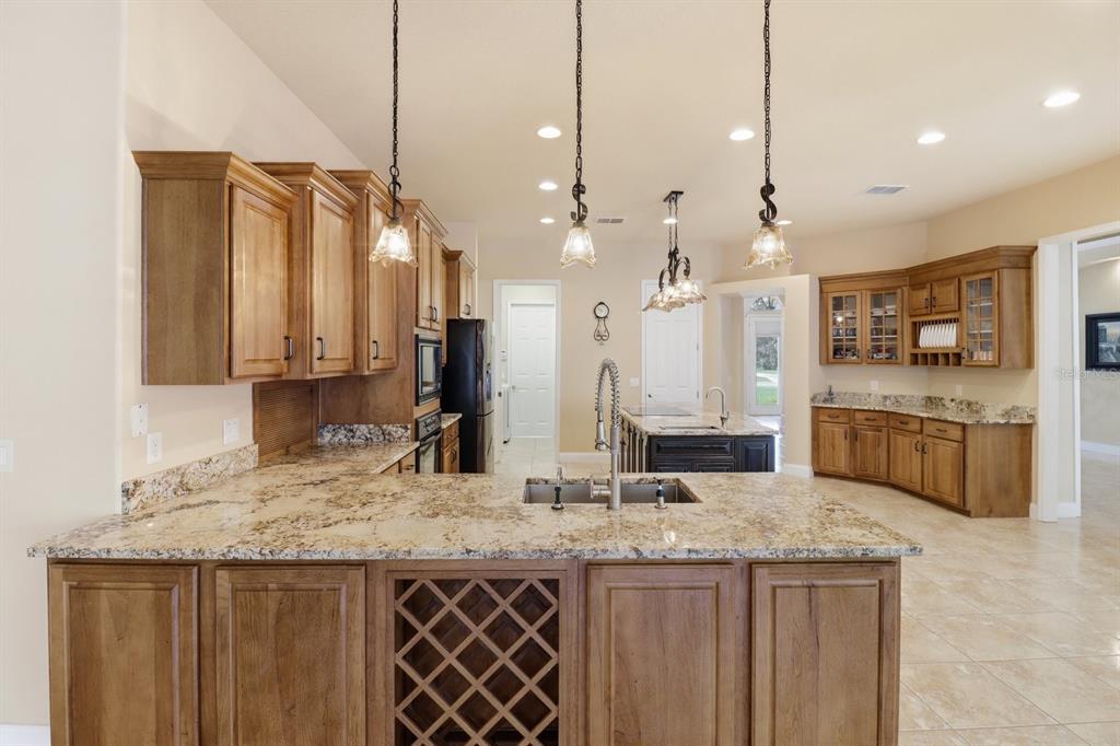 2125 Southeast 25th Loop Ocala, FL 34471 - Photo 14 of 60 a kitchen with kitchen island granite countertop a sink a center island and stainless steel appliances