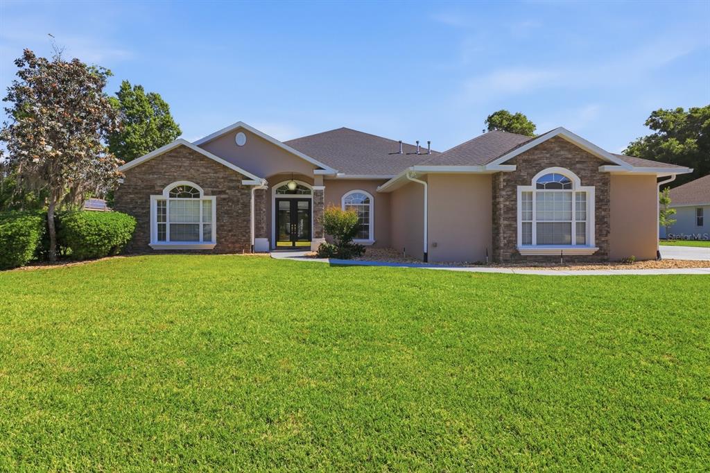 2125 Southeast 25th Loop Ocala, FL 34471 - Photo 4 of 60 a front view of a house with a yard and garage