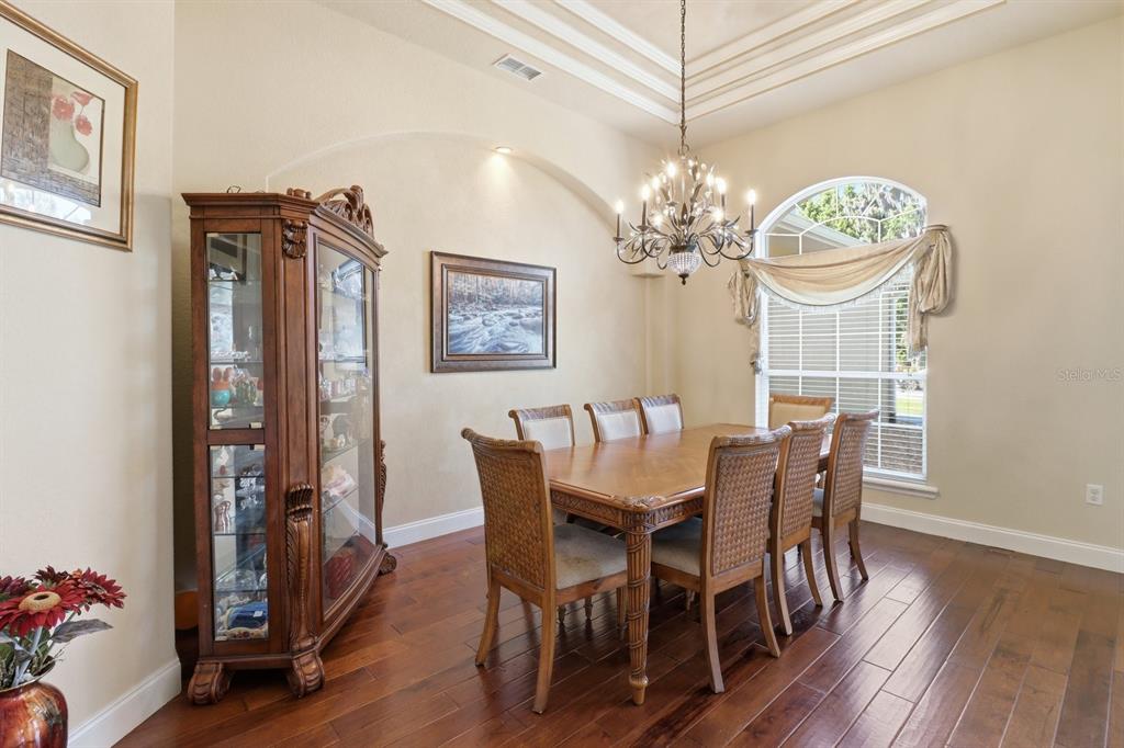 2125 Southeast 25th Loop Ocala, FL 34471 - Photo 9 of 60 a dining room with furniture a chandelier and wooden floor