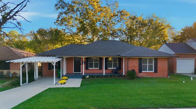 a view of a house with a yard and potted plants