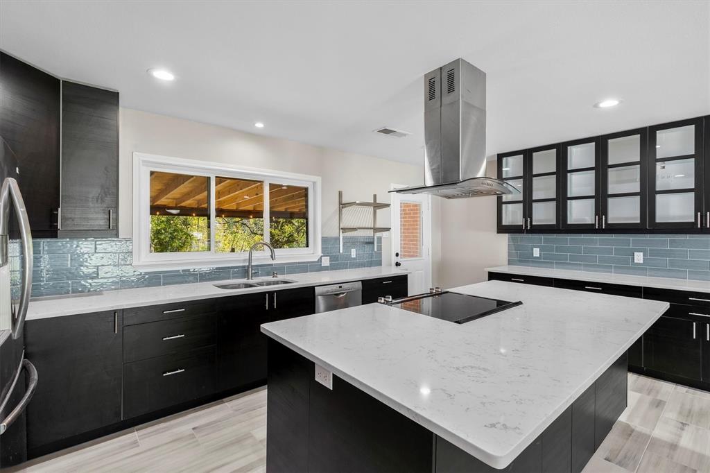 653 Kessler Boulevard Sherman, TX 75092 - Photo 4 of 30 a kitchen with stainless steel appliances kitchen island a table chairs in it and wooden floors