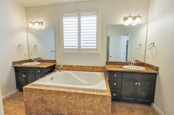 a bathroom with a tub sink and mirror