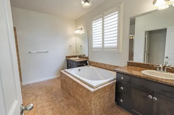 a bathroom with a tub sink and mirror
