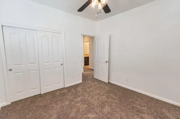 an empty room with chandelier fan
