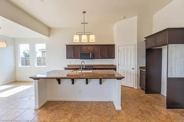 a kitchen with kitchen island stainless steel appliances a sink stove and refrigerator