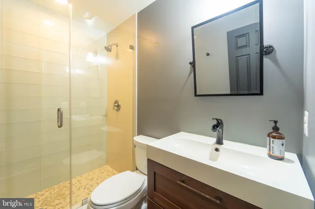 a bathroom with a sink mirror toilet and shower
