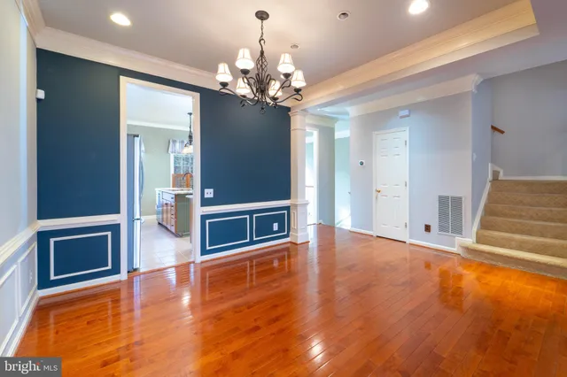 a view of a livingroom with a fireplace a chandelier and wooden floor