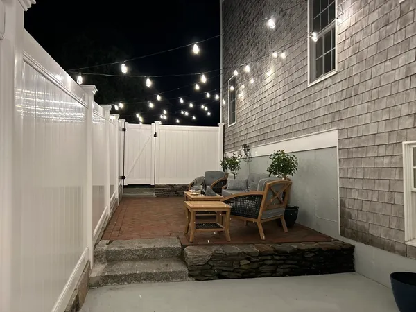 a view of a patio with table and chairs with wooden fence