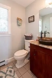 a bathroom with a granite countertop toilet a sink and a mirror